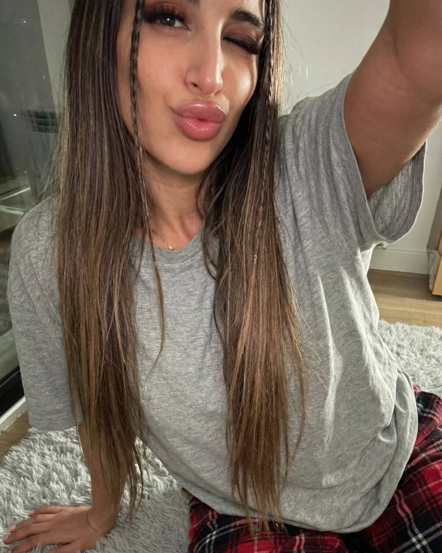 Lena sitting on a soft rug at home in a grey tee